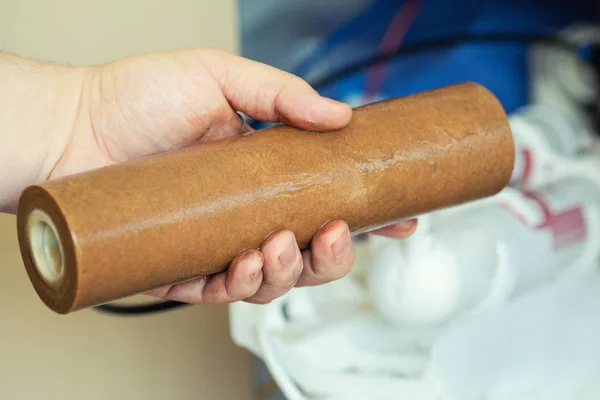 Close-up mão encanador segurando usado sujo enferrujado filtro de primeiro estágio para beber água. Mudança de cartucho do sistema de filtragem de equipamentos sanitários domésticos — Fotografia de Stock