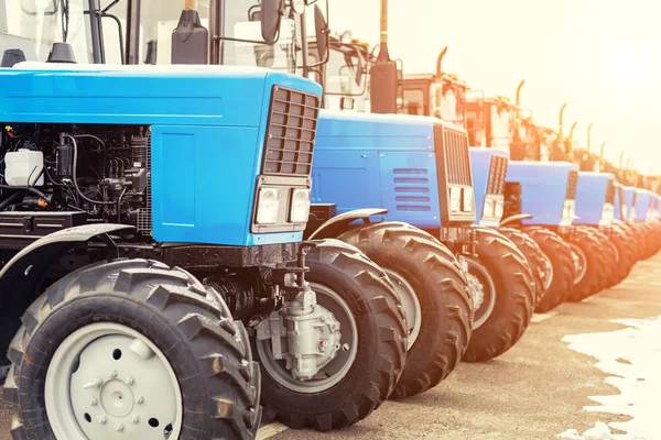 Muchos tractores diferentes en fila en la feria agrícola para la venta — Foto de Stock