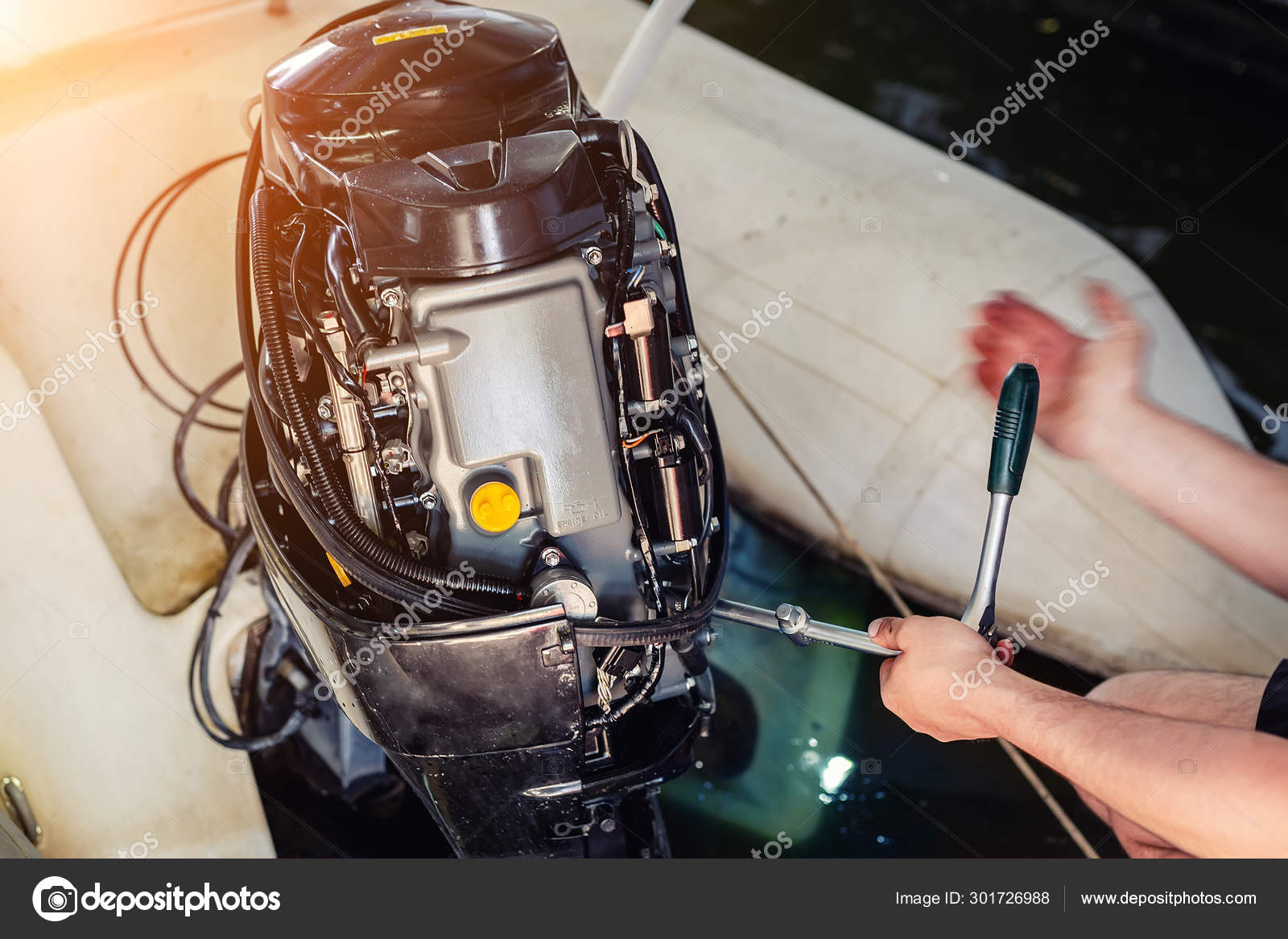 Mechanic repairing inflatable motorboat engine at boat garage. Ship