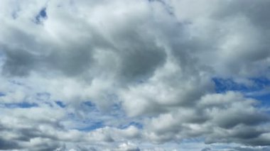 Parlak güneşli bir günde berrak canlı mavi gökyüzüne karşı yuvarlanan beyaz ve gri kabarık bulutlar. Sakin doğa bulutları zaman atlamalı. Fırtına ve yağmur hava durumu. Sonbahar gökyüzü.