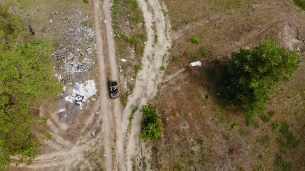 Vue du haut vers le bas de l'inspecteur de l'environnement ou forestier équitation VTT quadbike à travers la forêt polluée par le plastique et d'autres déchets différents. Mise en décharge illégale de déchets. Problème mondial de pollution terrestre. — Video