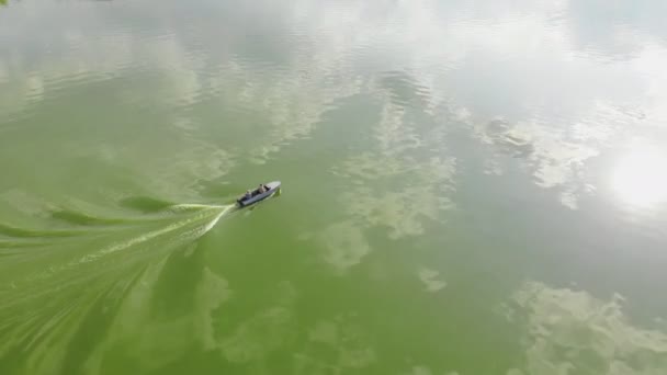 Två vuxna fiskare seglar på små gamla fiske motorbåt över vackra gröna alger blommande flod eller sjö på kvällen — Stockvideo