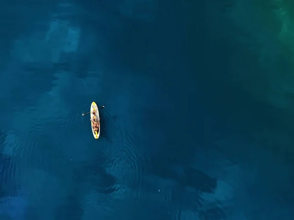 Vue aérienne de drone de la famille s'amusant à nager sur SUP stand up paddle planche de surf gonflable. Mère avec des enfants profiter assis sur la planche de surf à l'océan bleu clair ou l'eau de mer pendant les vacances — Photo