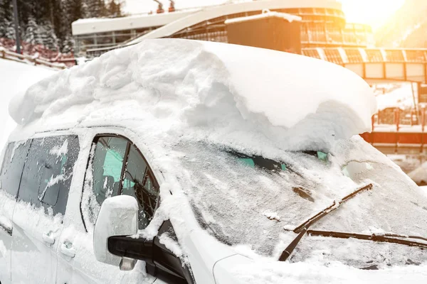 Car on a street covered with big thick snow layer after heavy snowfall. Extreme blizzard aftermath. Vehicle windshield with frozen window and wipers — Stock Photo, Image