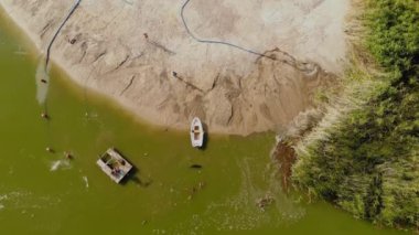 Özel yapım dredger pompa yıkama kum havadan drone görünümü ve nehir veya göl kıyısında kumlu silt kıyısında plaj besleyici yapma