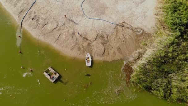 Vista aérea del dron de la bomba de dragado hecha a medida que lava la arena y hace que la playa se nutra en la costa del limo arenoso en la orilla del río o del lago — Vídeos de Stock