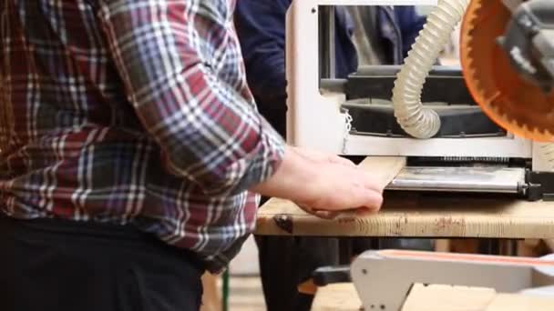 Elaboración artesanal de madera en carpintería con muchas herramientas eléctricas profesionales modernas. Hombre usando máquina de engrosamiento y sierra circular y otros equipos en el taller — Vídeo de stock