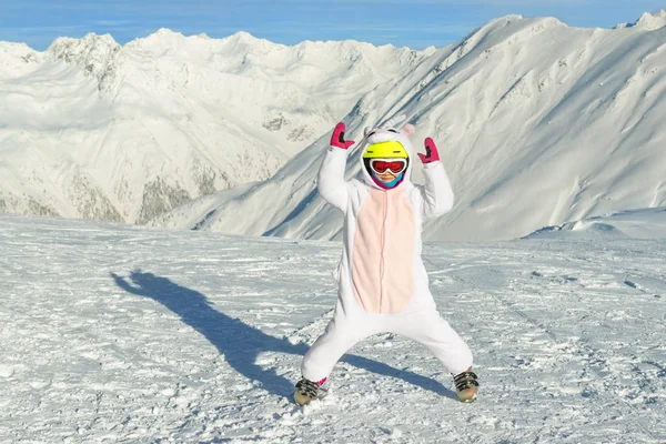 Bonito adorável pré-escolar branco menina retrato com esqui no capacete, óculos e traje divertido unicórnio desfrutar de atividades esportivas de inverno. Pequena criança esquiando em resort alpino de luxo nas montanhas — Fotografia de Stock