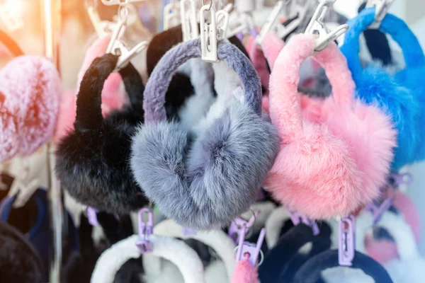 Lote de muitos multicolorido brilhante macio quente inverno fones de ouvido de pele e luvas penduradas no rack na exposição loja para venda. Bonito estação fria roupas acessórios — Fotografia de Stock