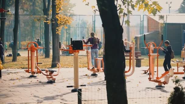 Κίεβο, Ουκρανία - 28 Σεπτεμβρίου 2019: Άνθρωποι που κάνουν αθλητικές ασκήσεις και προπόνηση σε δημόσιο υπαίθριο γυμναστήριο στο πάρκο της πόλης. Υγιεινός τρόπος ζωής — Αρχείο Βίντεο