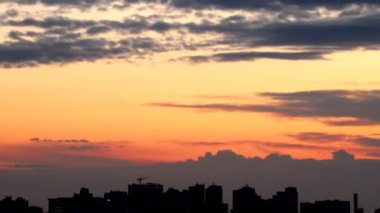 Şehir binalarının siluetleriyle dolu dramatik renkli, ateşli günbatımı gökyüzü manzarası. Doğal güzel şehir manzarası şafak arkaplan zaman aralığı. Metropolis Şehri Alacakaranlık Zamanı