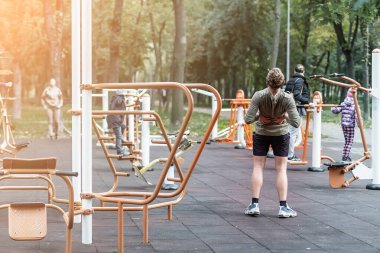 İnsanlar şehir parkındaki halka açık spor salonunda spor egzersizleri ve eğitim yapıyorlar. Sağlıklı yaşam tarzı kavramı