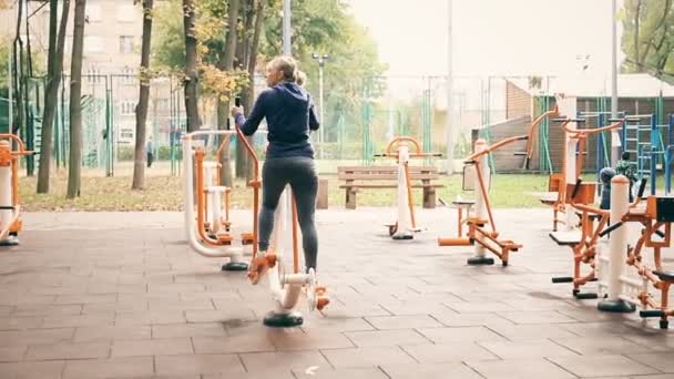 Kiev, Ukraina - 28 september 2019: Människor som gör sport övningar och träning på offentliga utomhus gym område i stadsparken. Friska livsstil koncept — Stockvideo