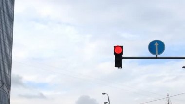 Trafik lambaları ve yuvarlak yol işaretleri şehir merkezindeki açık mavi gökyüzüne karşı sütunlara asıldı. Karınca araçları için izin sinyali