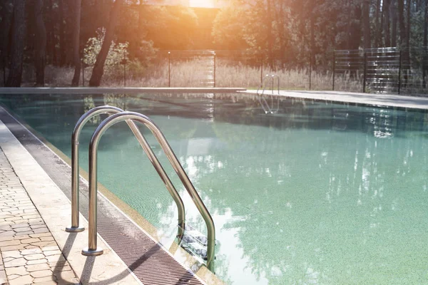 Gran piscina rectangular vacía de lujo con agua azul limpia y escalera en el complejo de playa del bosque tropical a la luz de la mañana amanecer y nadie al aire libre. Vida sana de ocio, viajes y ejercicio — Foto de Stock