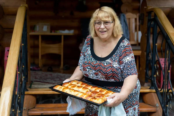 Smiling happy adorable senior woman grandma holding baking pan freshly cooked hot tasty fruit and berries filled pies cakes. Grandmother welcomes family to eat sweet bakery cookies pastry — Stock Photo, Image