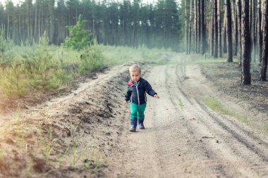 Şirin, sevimli, sarışın, beyaz bir çocuk. Çiftlikte kır yolu kenarında tek başına yürüyor. Ya da gündoğumunda kozalaklı ormanda çiftlikte. Doğayı keşfeden küçük bir çocuk.