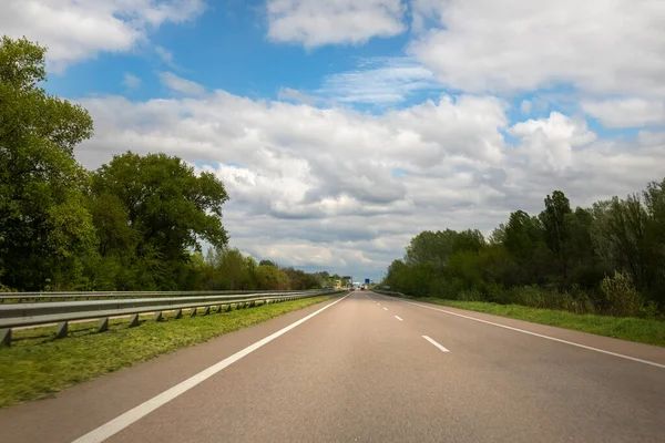 Emtpy carretera suburaban con movimiento borroso velocidad rápida conducción contra el cielo azul en el fondo. Perspectiva vehículo autopista paisaje Fotos de stock libres de derechos