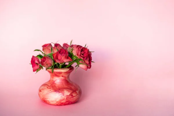 Zijaanzicht van minimalistische malse kleine roze rozenbloemboeket in kleine keramische vaas op pastelachtergrond. Flat lay vintage retro stijlvolle handgemaakte kunstwerk bloemdecoratie — Stockfoto
