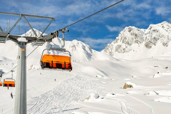 Remontées mécaniques sur les collines station d'hiver de montagne alpine par une journée ensoleillée. Téléski télésiège téléphérique avec les gens aiment le ski et le snowboard.Bannière panoramique large vue sur les pistes de descente — Photo