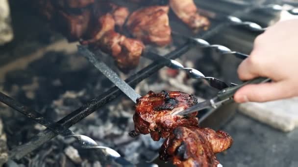 Просмотр человек резки курицы или индейки филе мяса с ножом проверки готовности на жаровне приготовления на горящем угле с огнем пламени и дыма. традиционная восточноевропейская барбекю домашняя еда на заднем дворе — стоковое видео