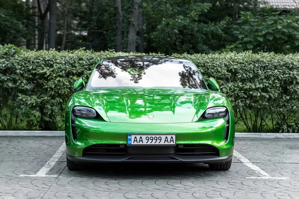 Kyiv, Ukrayna - 6 Eylül 2020: Yeni elektrikli sıfır emisyon spor otomobili Porsche Taycan turbo Mamba yeşil metalik rengi sonbahar günü şehir sokaklarında park halinde.