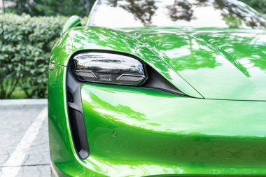 Kyiv, Ukrayna - 6 Eylül 2020: Yeni elektrikli sıfır emisyonlu spor araba Porsche Taycan turbo Mamba yeşil metalik rengi sonbahar günü şehir caddesinde park halinde.
