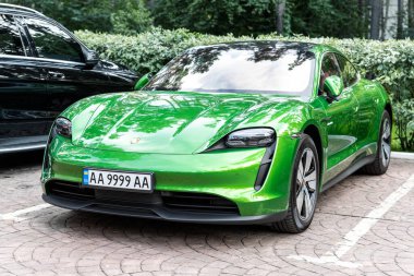 Kyiv, Ukrayna - 6 Eylül 2020: Yeni elektrikli sıfır emisyon spor otomobili Porsche Taycan turbo Mamba yeşil metalik rengi sonbahar günü şehir sokaklarında park halinde.