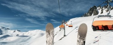 Alp tepelerinin manzaralı panoramik manzarası tepenin tepesinde kayak kaldırma halatı ve güneşli bir günde kar makineleri yapmak. İnsanlarla yokuş aşağı ve berrak mavi gökyüzü.