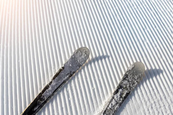Панорама точки зрения лыжников ноги на склоне начинают прямые ряды линии свежеприготовленный ухоженный лыжный склон трассы на ярком дне синего неба фоне. Зимний курорт в Европе, покрытый снегом — стоковое фото