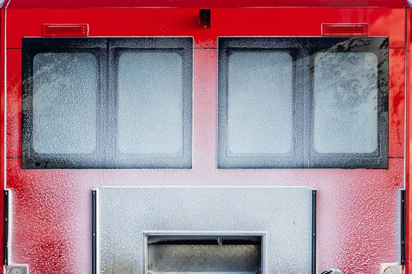 Visão traseira da janela da porta traseira coberta com neve após nevasca nevasca de neve moderna máquina de grooming ratrack snowcat vermelho depois de preparar pista de esqui pista de esqui alpino resort. Ilusão de semelhança de rosto humano — Fotografia de Stock