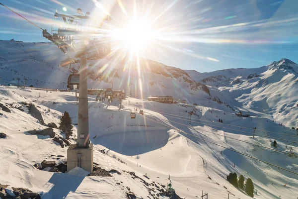 Панорамный вид на горнолыжный курорт Идальп со множеством горнолыжных склонов, лыжных трасс, подъемников для лыжных кресел, гондолы против горного ландшафта и яркие вспышки солнцезащитных линз на роскошном австрийском зимнем курорте Ишгль. досуг — стоковое фото