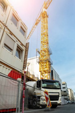 Ticari ya da konutsal Hightower inşaat şantiyesi ve farklı ağır makineler. Beton karıştırıcı kamyon ve bir sürü vinç. Modüler taşınabilir kabini olan endüstriyel işyeri