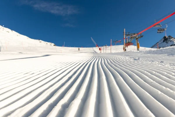 一排排整整齐齐的新准备的直线滑雪板滑行 阳光灿烂 蓝天背景清澈 欧洲冬季滑雪场雪山下坡景观 — 图库照片