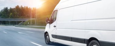 Beyaz modern teslimat küçük kargo kargo kargo minibüsü şehir merkezine giden otoyolda hızla ilerliyor. İşletme dağıtımı ve lojistik ekspres hizmeti. Otoyol gününde mini otobüs yolculuğu. Pankart.