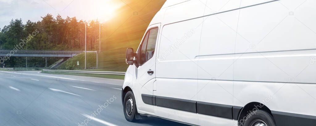 White modern delivery small shipment cargo courier van moving fast on motorway road to city urban suburb. Busines distribution and logistics express service. Mini bus driving on highway day. banner.