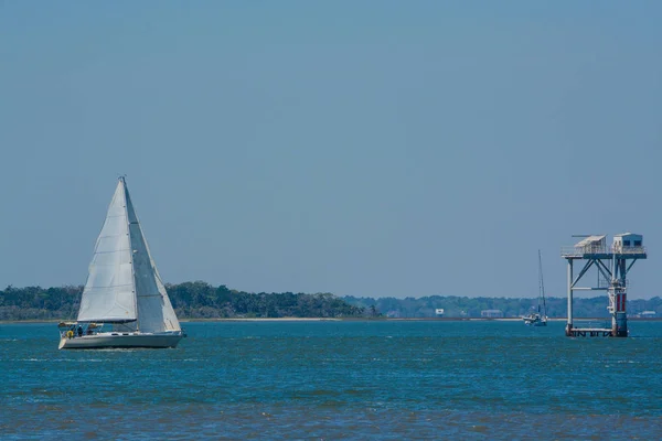 Sailboat sailing past the Florida Georgia state line marker on Cumberland Sound. Fernandina Beach, Nassau County, Florida USA