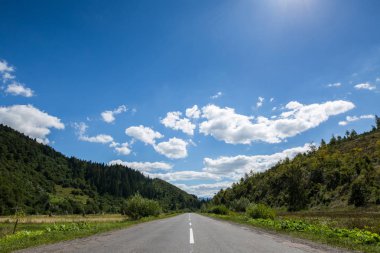 Boş asfalt karayolu otoyol ormanlık dağlarda, bulutlu bir gökyüzü arka plan