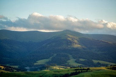Fırtına bulutları dağların ve gün batımı sırasında orman.