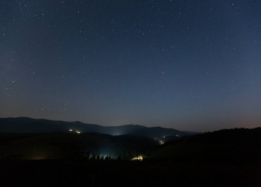 Dağ ve dağ köyü yaz geceleri üzerinde yıldızlı gökyüzü.
