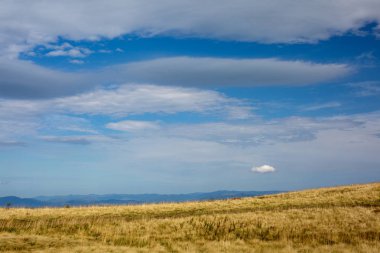 Bulutlar dağ aralığı boyunca alışılmadık şekli. Harika bir manzara.