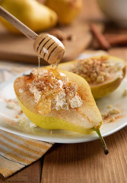 Media pera con requesón, nueces, miel y canela en plato blanco . — Foto de Stock