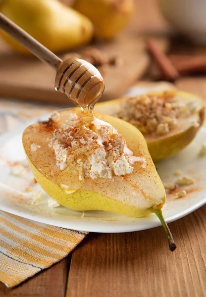 Peras con requesón, nueces, miel y canela sobre plato blanco . — Foto de Stock