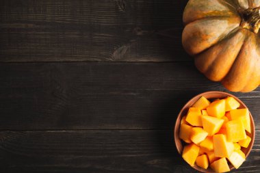 Büyük iştah açıcı bütün kabak ve bir tabak kabak dilimleri siyah ahşap zemin ile. Uzay kopyalayın. Üstten görünüm.