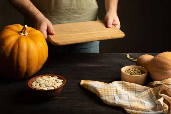 Cutting board in male hands. Preparation for cutting pumpkin. — Stock Photo, Image