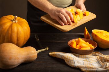 Cook kabak dilimlerini bir kesme tahtası derin bir kasenin içine atar.