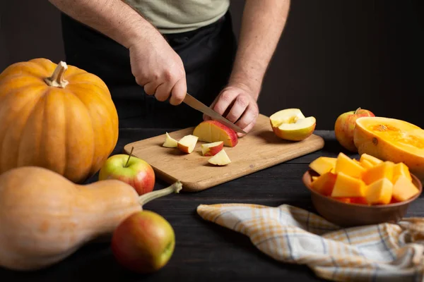 Cook Cuts Apple Pieces Baking Wooden Black Table Lie Pumpkins — Stock Photo, Image