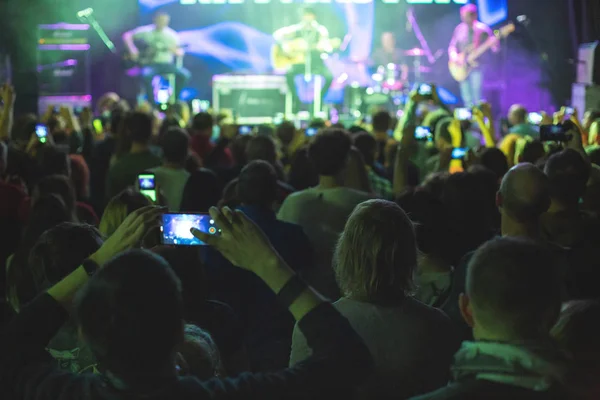 Tłum koncert z podniesionymi rękami, sylwetki ludzi z smartfonów. — Zdjęcie stockowe