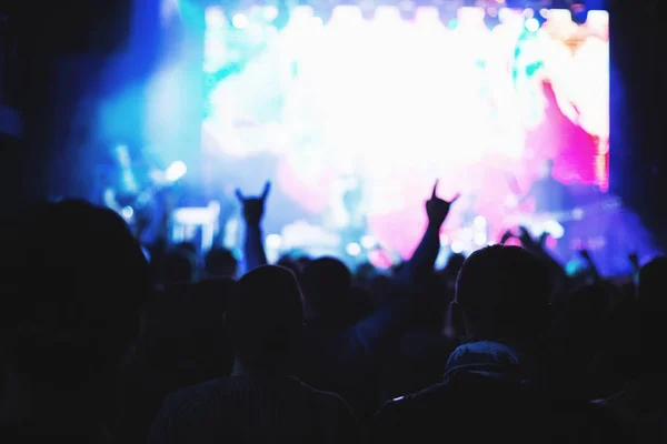 Siluetas de una multitud de conciertos frente a un escenario iluminado en una discoteca . —  Fotos de Stock