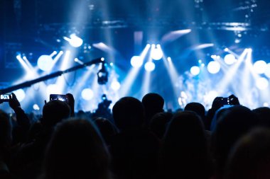 Bir konser kalabalık silüeti. Seyirciler sahne doğru görünüyor.